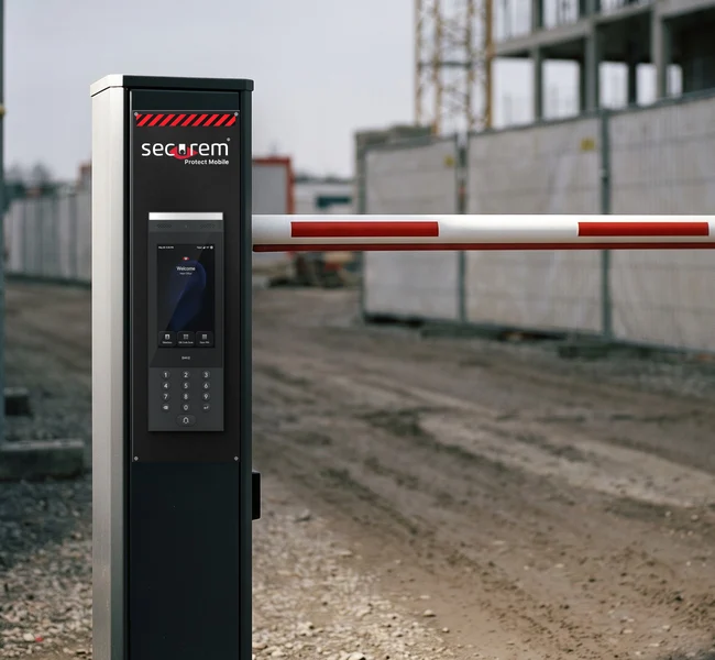 Access Protect Mobile : grand vidéophone sur borne noire Securem, devant une barrière levante de chantier