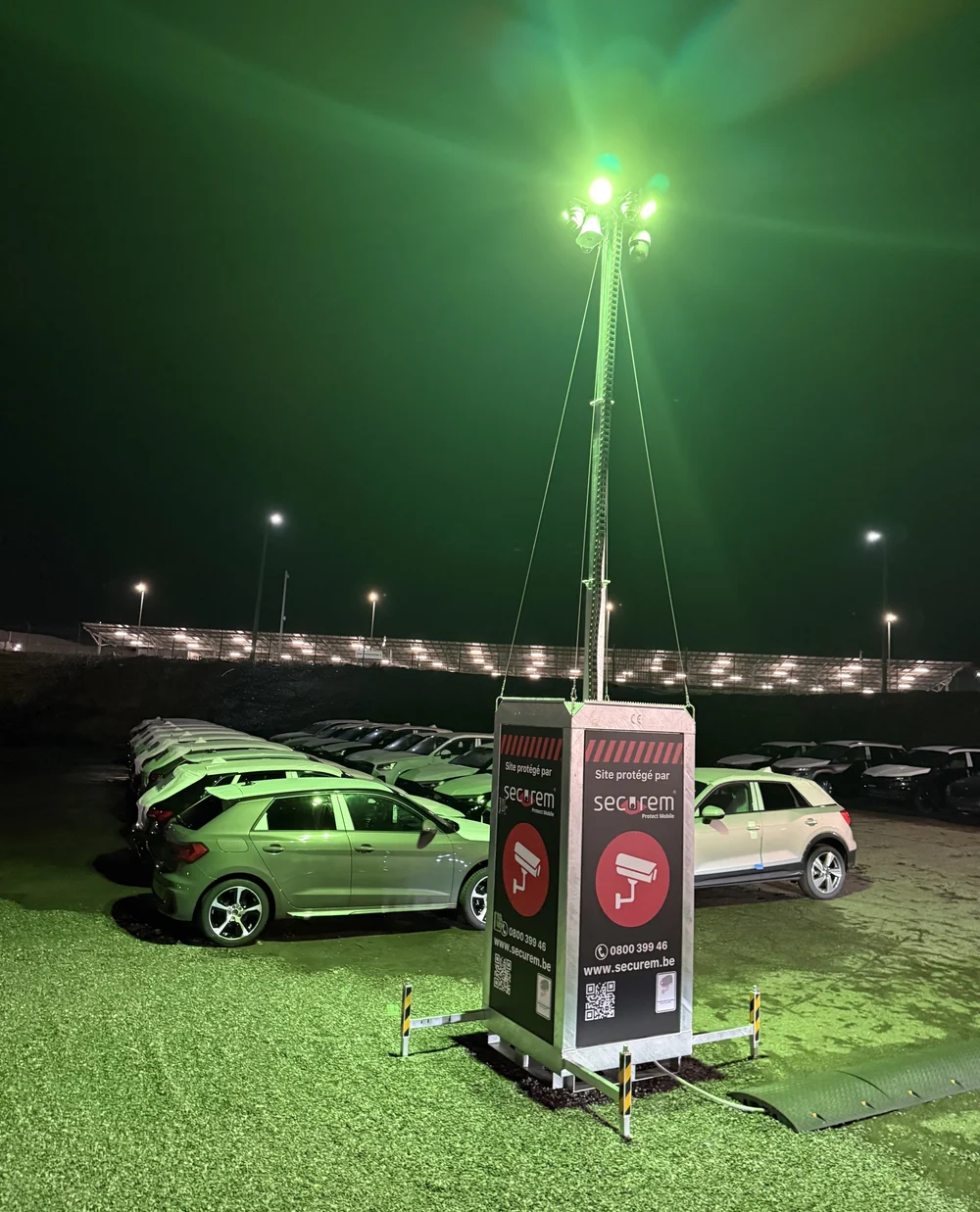 Mât Securem Protect Mobile installé et éclairé de nuit, surveillant un parc de véhicules