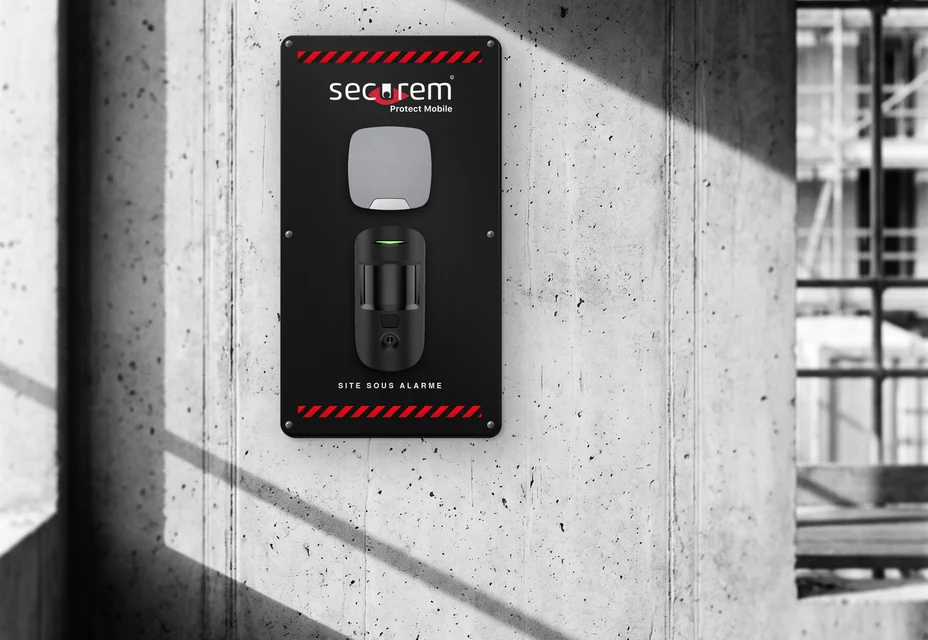 Secure Protect Mobile : panneau noir Securem Protect Mobile avec sirène et détecteur de mouvement à photo, fixé au mur d.un chantier